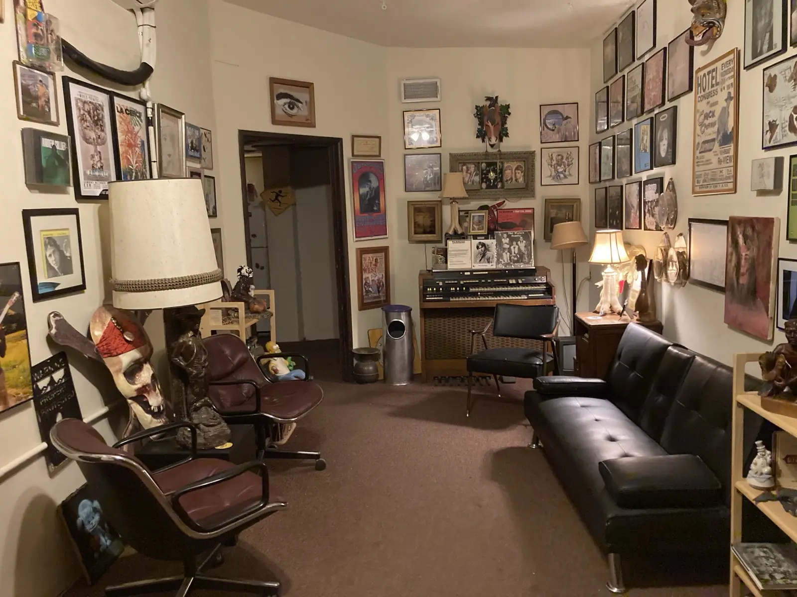 The studio lobby: walls covered floor to ceiling in framed posters and art, a leather couch, an organ, a giant lamp and a pirate skull.